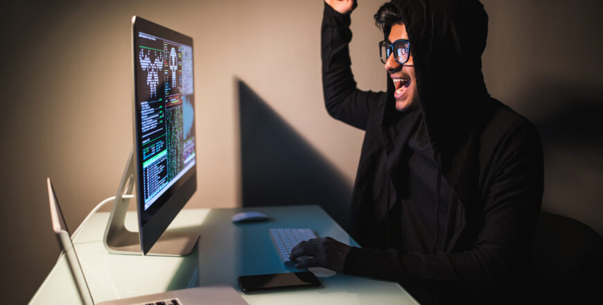 indian-hacker-wear-mask-using-laptop-empty-white-room.jpg